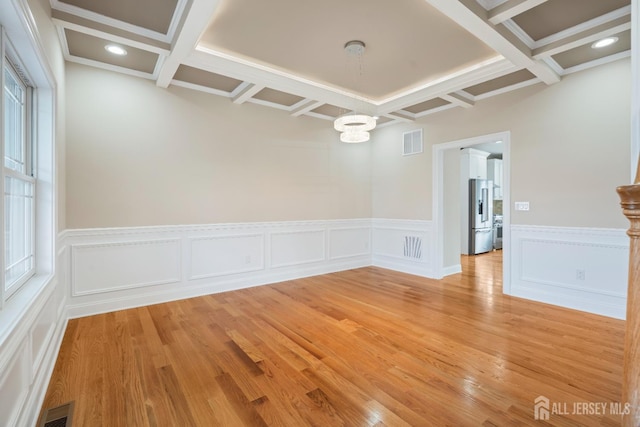 spare room featuring visible vents, beam ceiling, and coffered ceiling