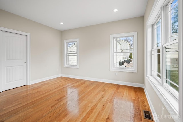spare room with baseboards, light wood finished floors, visible vents, and recessed lighting