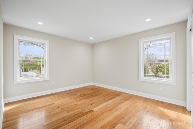 unfurnished room featuring light wood finished floors, baseboards, and recessed lighting