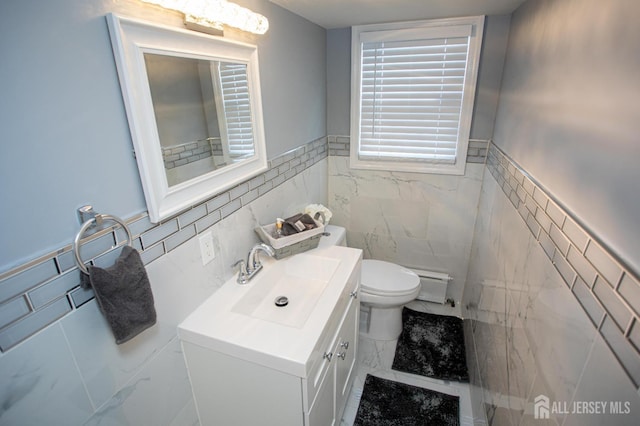 719 Charles St, South Amboy, NJ 08879 - bathroom with tile walls, marble look tiles, vanity, baseboard heating, and a wainscoted wall