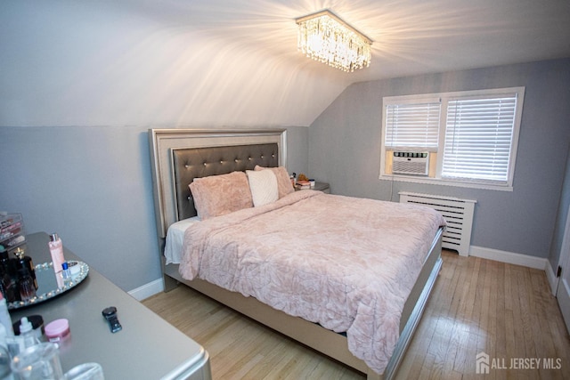 719 Charles St, South Amboy, NJ 08879 - bedroom featuring wood finished floors, vaulted ceiling, cooling unit, radiator, and a chandelier