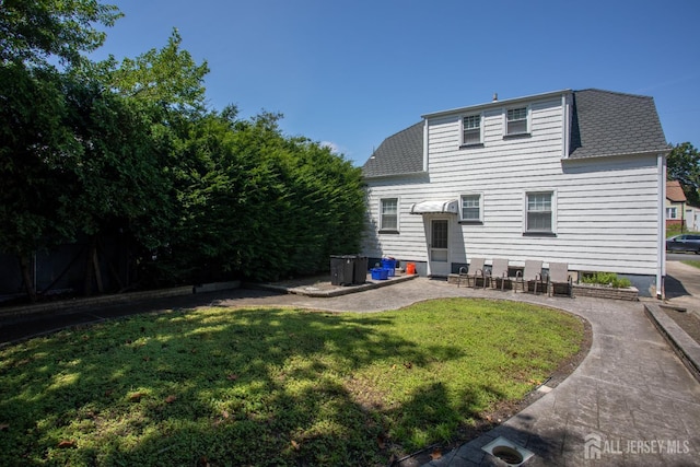 719 Charles St, South Amboy, NJ 08879 - rear view of house with a yard, a shingled roof, and a patio area