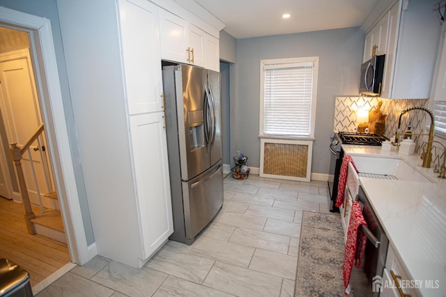 719 Charles St, South Amboy, NJ 08879 - kitchen with stainless steel appliances, white cabinets, backsplash, recessed lighting, and light stone counters