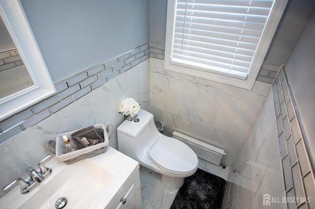 719 Charles St, South Amboy, NJ 08879 - half bathroom featuring a baseboard heating unit, tile walls, vanity, and wainscoting