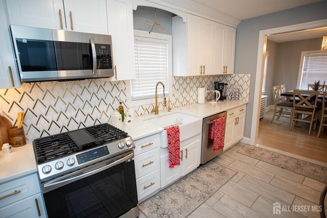 719 Charles St, South Amboy, NJ 08879 - kitchen featuring stainless steel appliances, white cabinets, light countertops, and decorative backsplash