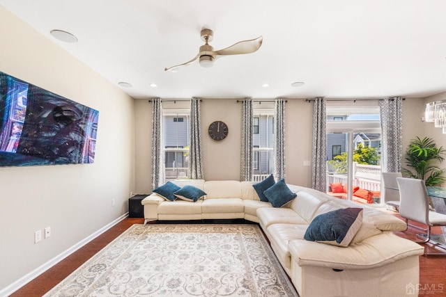 living area featuring a ceiling fan and baseboards