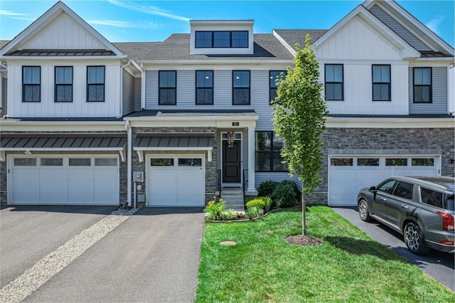 multi unit property featuring driveway, stone siding, and board and batten siding