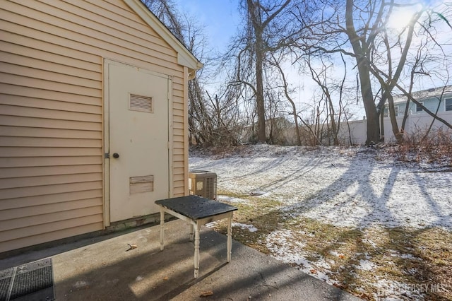 snow covered patio with cooling unit