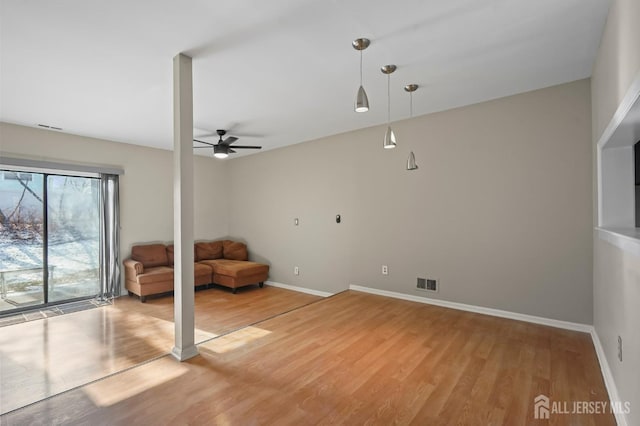 unfurnished room featuring light wood-style floors, a ceiling fan, and baseboards