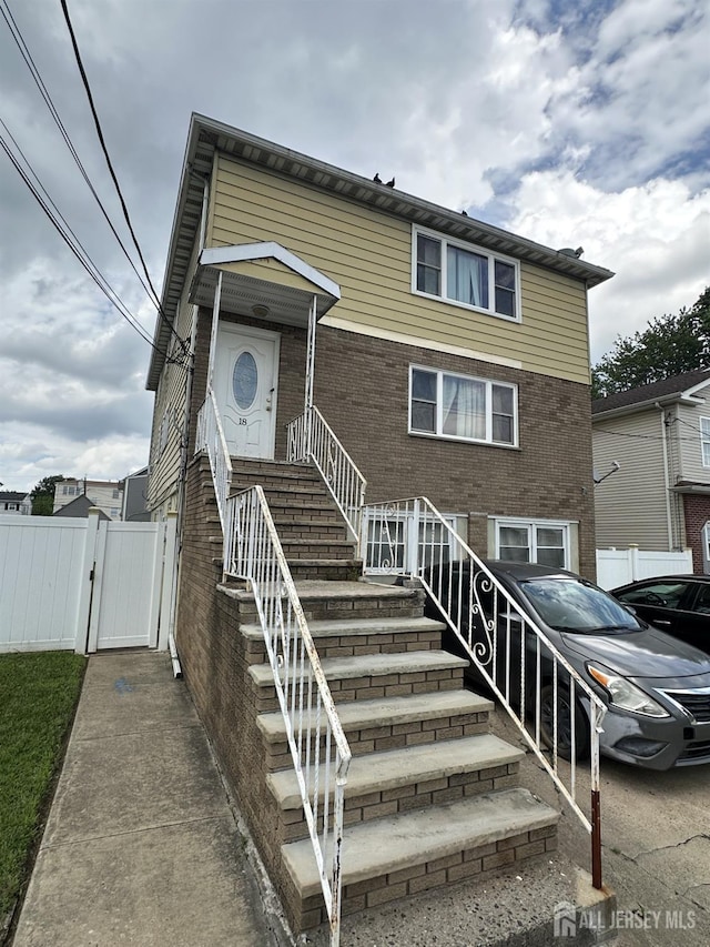 18 Noe St SE, Carteret, NJ 07008 - view of property featuring brick siding and a gate