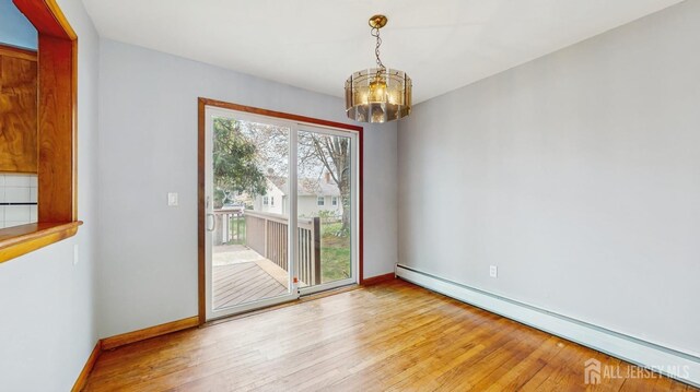 190 S Moetz Dr S, Milltown, NJ 08850 - unfurnished dining area with baseboard heating, a chandelier, hardwood / wood-style floors, and baseboards