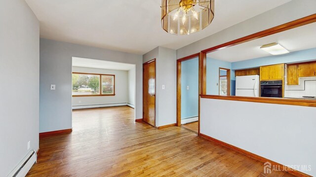 190 S Moetz Dr S, Milltown, NJ 08850 - unfurnished living room with a baseboard heating unit, a baseboard radiator, a chandelier, and light wood-style floors