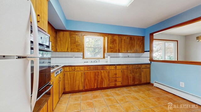 190 S Moetz Dr S, Milltown, NJ 08850 - kitchen featuring baseboard heating, brown cabinets, tasteful backsplash, light countertops, and freestanding refrigerator