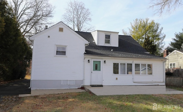 rear view of house featuring a shingled roof, a patio area, and fence