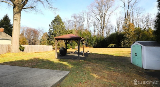 view of yard with a patio, a gazebo, fence, an outdoor structure, and a shed