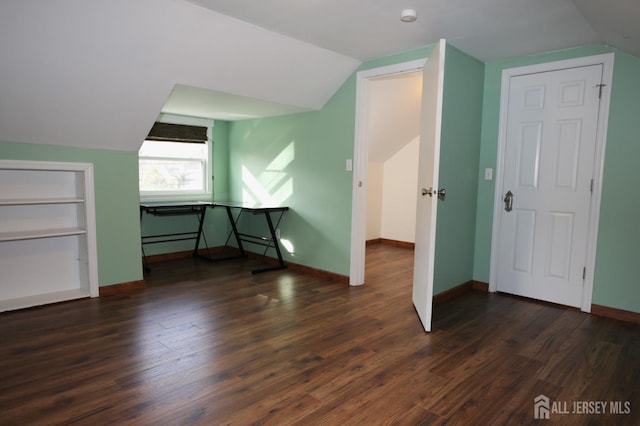 bonus room with dark wood-style floors, baseboards, and vaulted ceiling