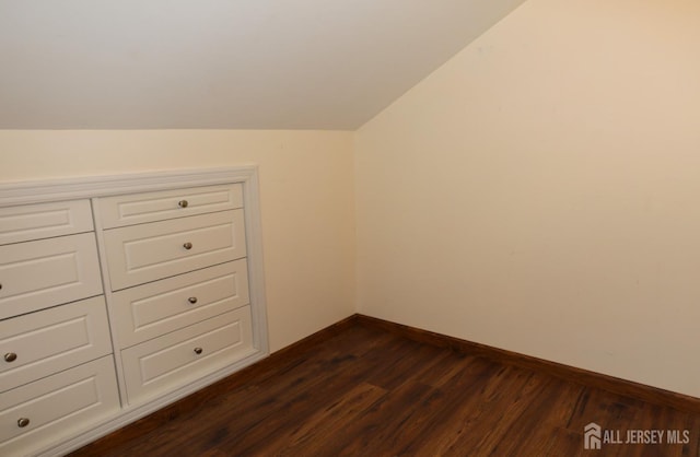 interior space with lofted ceiling, dark wood-style floors, and baseboards