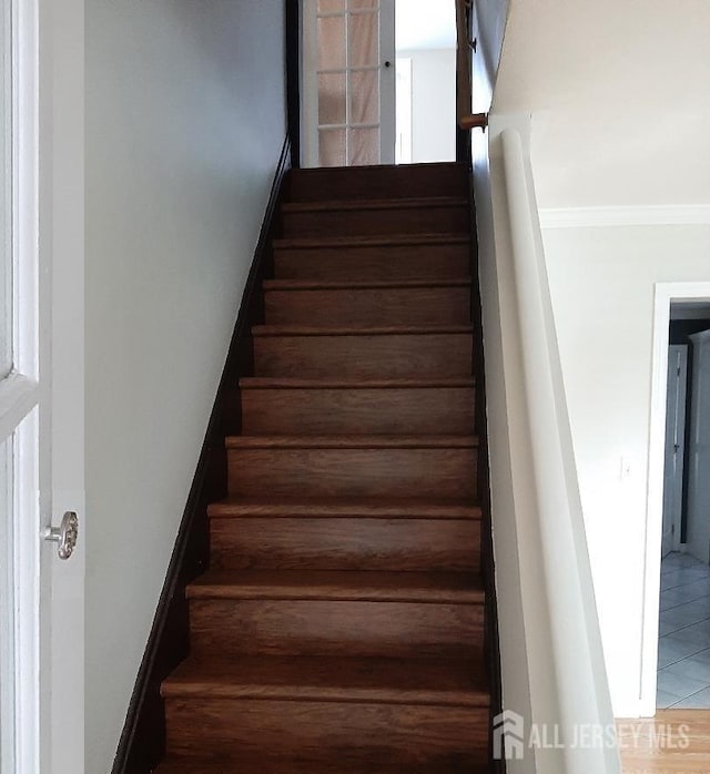 stairway featuring ornamental molding