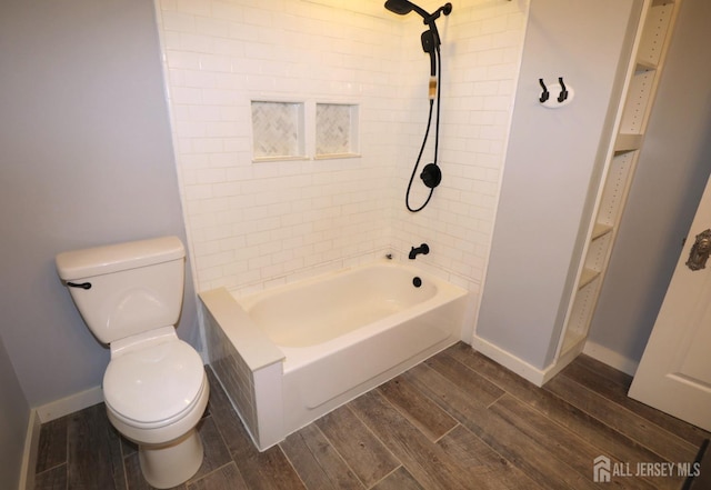 bathroom featuring toilet, shower / bath combination, baseboards, and wood finish floors