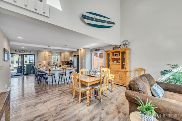 dining room with recessed lighting, a healthy amount of sunlight, and light wood-style floors