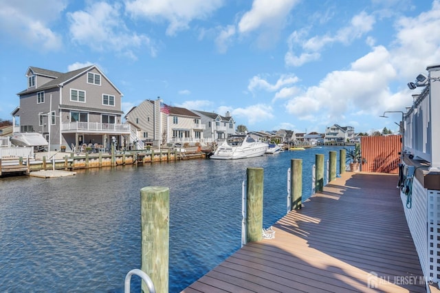 view of dock with a residential view and a water view