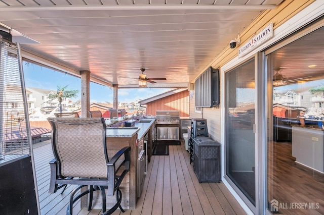wooden terrace with a ceiling fan, a sink, and a grill
