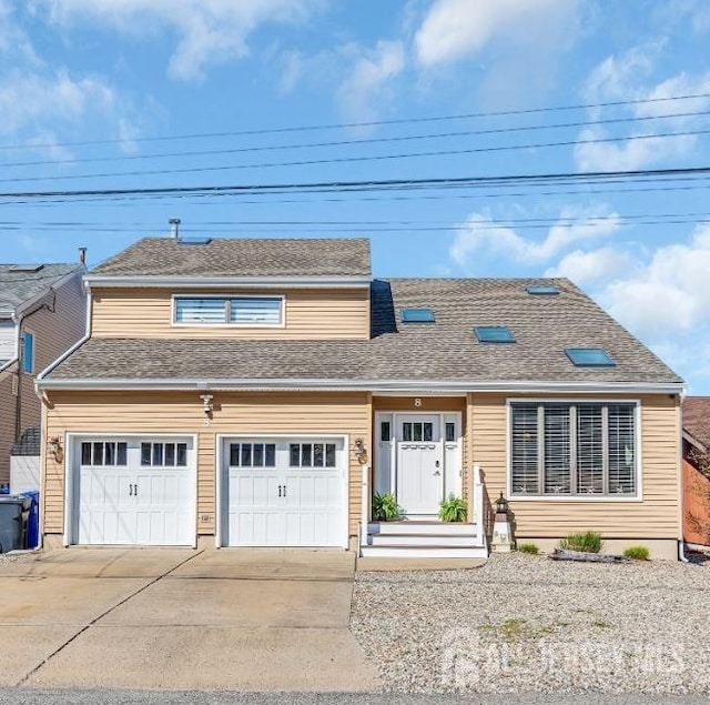 view of front of property featuring a shingled roof, concrete driveway, and an attached garage