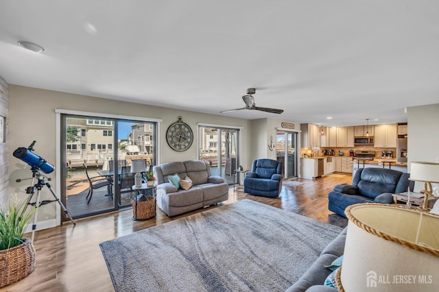 living room with recessed lighting, a ceiling fan, baseboards, and light wood-type flooring