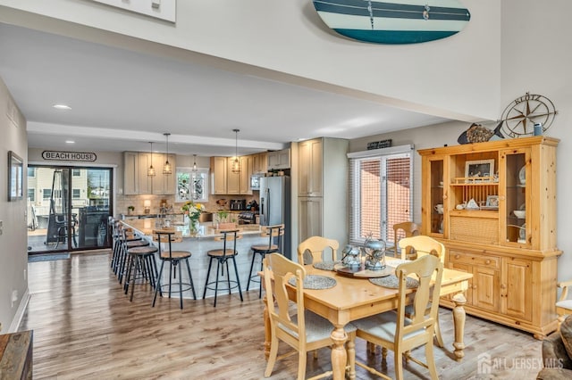 dining space with baseboards, recessed lighting, and light wood finished floors