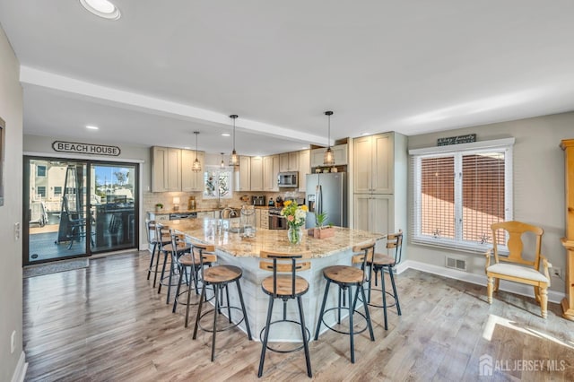 kitchen with visible vents, baseboards, appliances with stainless steel finishes, and light wood-type flooring