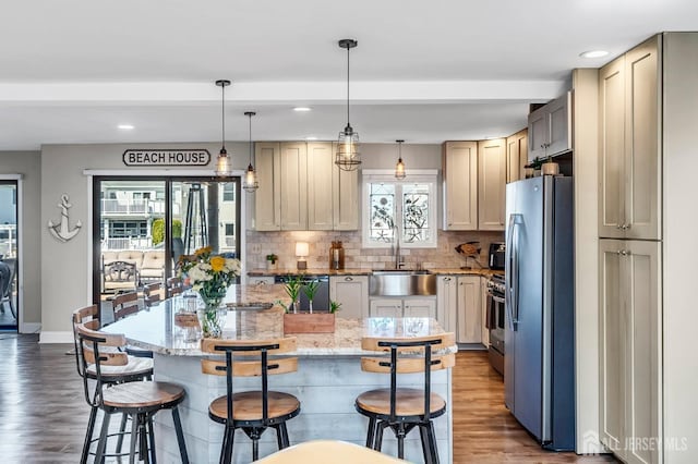 kitchen featuring wood finished floors, freestanding refrigerator, backsplash, a sink, and dishwashing machine