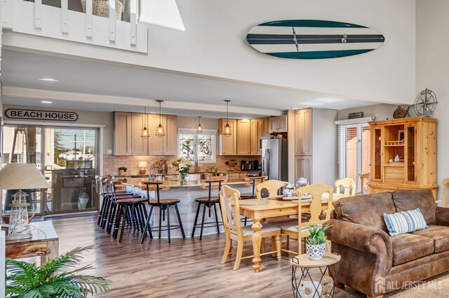 living room with light wood-style floors and a towering ceiling
