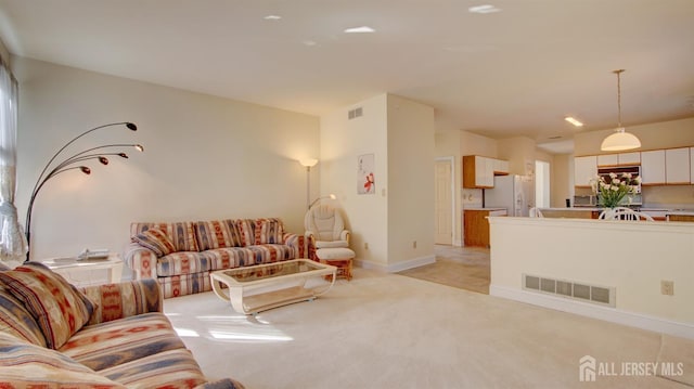 living room featuring light carpet and baseboards