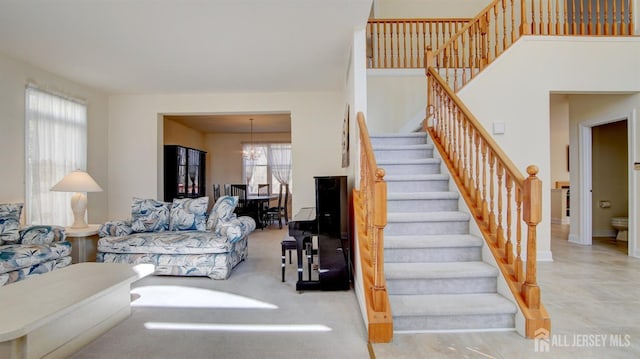 stairway featuring a chandelier and baseboards
