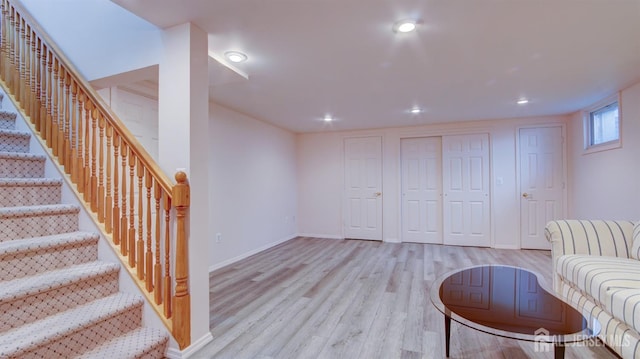 unfurnished living room with wood finished floors, stairway, recessed lighting, and baseboards