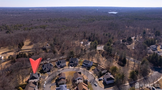 aerial overview of property's location with a forest and nearby suburban area