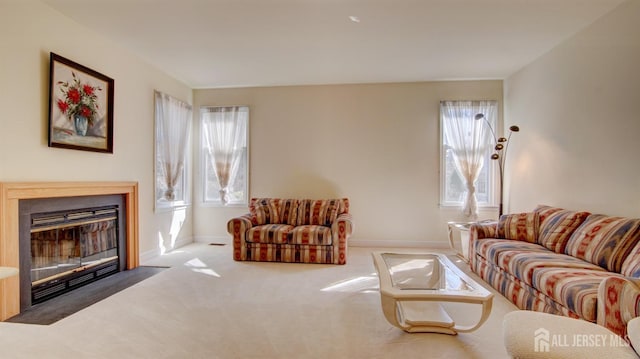 living area featuring baseboards, a fireplace with flush hearth, and carpet