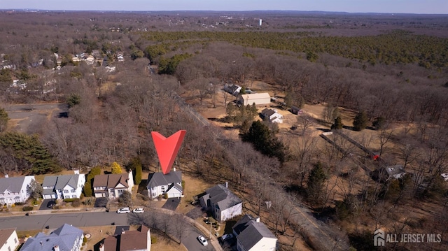 aerial view of property and surrounding area with nearby suburban area and a forest