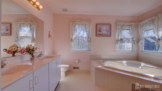 full bath featuring a bath, tile patterned flooring, toilet, and double vanity