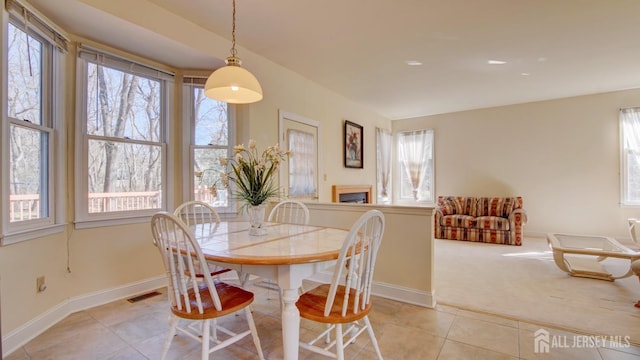 dining room featuring light tile patterned floors, baseboards, and light carpet