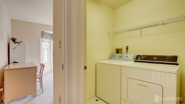 washroom with washer and dryer and baseboards