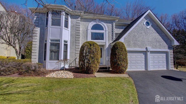 view of front of property with an attached garage, driveway, and a front yard