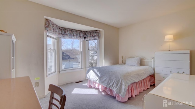 bedroom with light carpet and baseboards