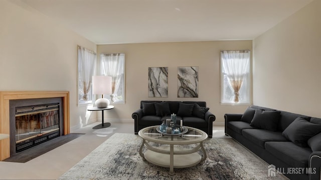 living area with a fireplace with flush hearth, plenty of natural light, and baseboards