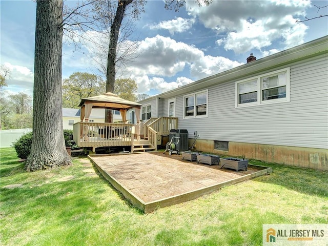 rear view of house featuring a gazebo, a yard, a wooden deck, a patio, and a chimney