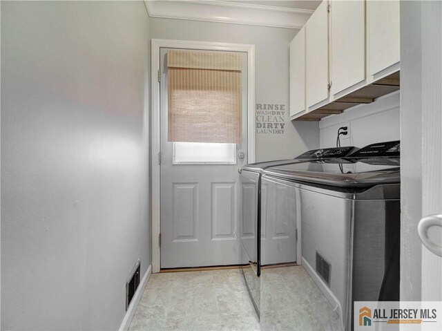 laundry area with washer and clothes dryer, cabinet space, and ornamental molding