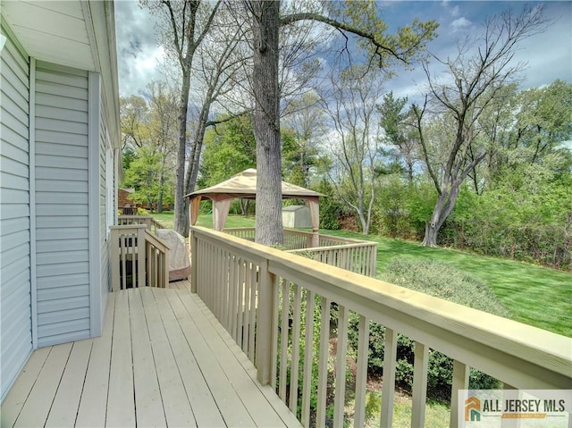 wooden deck featuring a gazebo and a yard