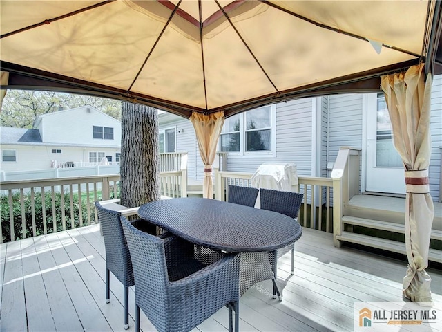 wooden deck featuring a gazebo and outdoor dining area