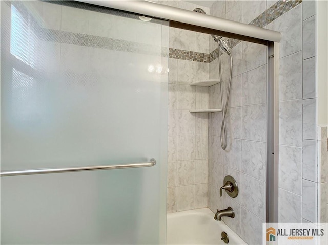 bathroom with combined bath / shower with glass door