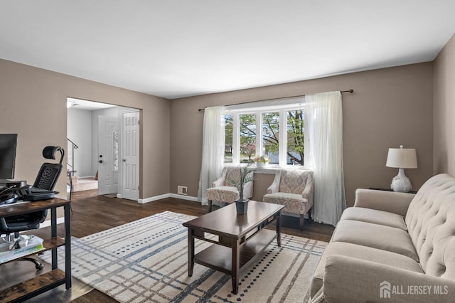 living room featuring baseboards, visible vents, and wood finished floors